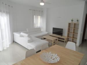 a living room with a white couch and a table at PLAYA SAN JUAN, Casa Vacacional CENTRICA in Playa de San Juan