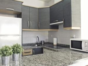 kuchnia z białą lodówką i czarnymi szafkami w obiekcie CHALET 84 con PISCINA PRIVADA w mieście Callao Salvaje