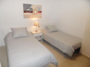 2 camas en una habitación con una lámpara en una mesa en AUREA, estancia EN SANTA CRUZ, SUPER CENTRICO! en Santa Cruz de Tenerife