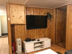 a living room with a television on a wooden wall at Nordhagen 17 in Stavanger