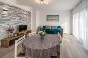- un salon avec une table et un canapé bleu dans l'établissement Apartmani Polonijo Nada, à Krk