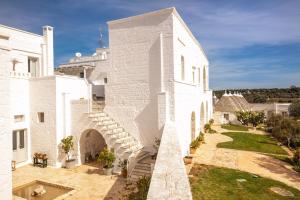 a white building with a staircase on the side of it at Masseria Cervarolo in Ostuni