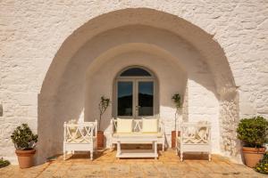 two white chairs and a window in a building at Masseria Cervarolo in Ostuni