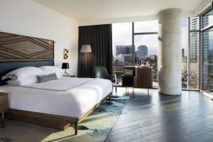 a bedroom with a large bed and a large window at Thompson Nashville, by Hyatt in Nashville