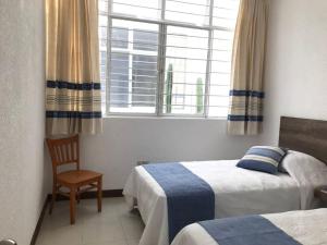 - une chambre avec deux lits, une fenêtre et une chaise dans l'établissement Oaxaca at your doorstep (3), à Oaxaca