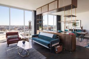 a living room with a blue couch and some windows at Thompson Nashville, by Hyatt in Nashville