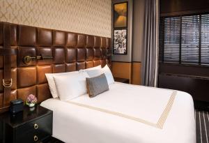 a hotel room with a bed and a dresser at Gild Hall - A Thompson Hotel in New York