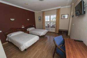 a hotel room with two beds and a table at Hotel Carabela Santa María in Mazagón