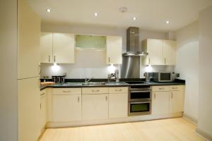 una cucina con mobili bianchi e un lavandino di 2 bed 2 bath at Pelican Hse in Newbury - FREE secure, allocated parking a Newbury