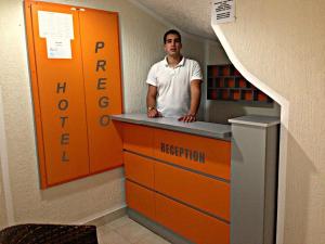a man standing at a counter in an office at Apartment Hotel Prego in Ulcinj