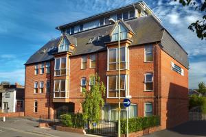 a red brick building with a black roof at 2 bed 2 bath at Pelican Hse in Newbury - FREE secure, allocated parking in Newbury