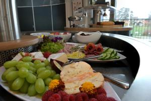two plates of food on a table with grapes and meat at Skærbæk Holiday Center in Skærbæk