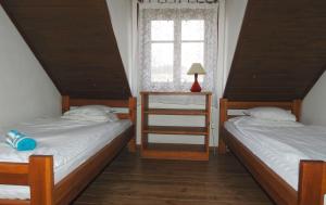two twin beds in a room with a window at Łosinek in Dolistowo