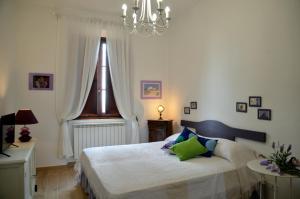 a bedroom with a bed with a window and a chandelier at Donnaberarda in Cortona