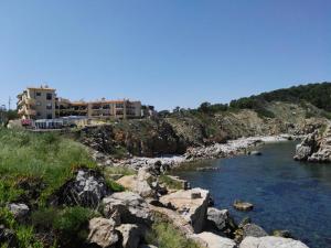 a resort on a rocky shoreline with a body of water at APARTAMENT MAGNIFIQUES VISTES- PORT DE REI in L'Escala