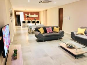 uma sala de estar com sofás e uma sala de jantar em The Executive - Exclusive Self-Catering Apartments - Ezulwini em Ezulwini