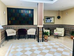 Hotel Puerta Nazarí في أورخيفا: لوبي فيه كراسي وطاولة ومرآة