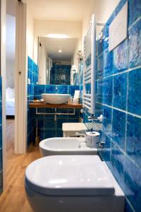 a blue tiled bathroom with a toilet and a sink at Sopra Le Mura in Castellammare del Golfo