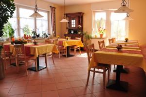 a restaurant with tables and chairs with yellow table cloth at Landhaus Warndtwald Dependance in Wadgassen