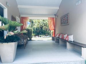 a hallway with benches and plants in a house at Paraty Bungalows Bar E Hotel in Paraty