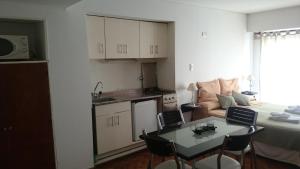 a kitchen and a living room with a table and chairs at Temporarios Peatonal in Rosario