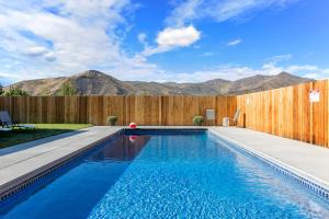 a swimming pool with a fence and mountains in the background at Silver Creek Hotel in Hailey