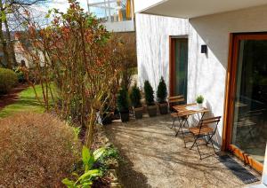 une terrasse avec une table et des chaises à côté d'une maison dans l'établissement Wohlfühl-Apartment Bad Kissingen II, à Bad Kissingen