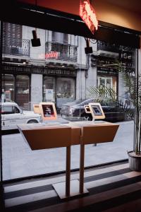 a table with three computers on it in front of a window at Select Sol in Madrid +37 photos
