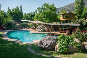 a swimming pool with a gazebo and a house at Cascada Lodge Cajon del Maipo in San José de Maipo