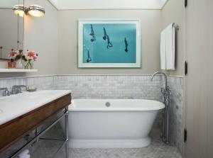 a bathroom with a bath tub and a picture of birds at The Beekman, a Thompson Hotel, part of Hyatt in New York