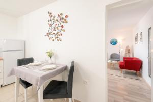 a white dining room with a white table and chairs at Apartment Adventure in Split