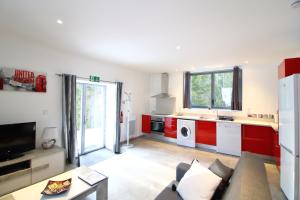 a living room with a couch and a kitchen at Le Moulin des Olirics in Sallanches