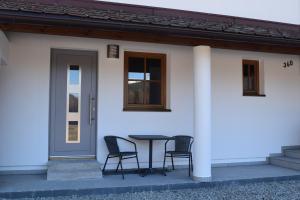 a table and chairs in front of a white house at Appart ÖtztAlpin in Längenfeld +15 photos