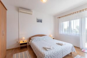 Habitación blanca con cama y ventana en Apartments Mimi, en Trogir
