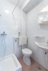 Baño blanco con aseo y lavamanos en Apartments Mimi, en Trogir