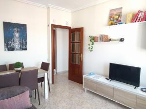 a living room with a television and a table with chairs at Manzanera, junto Ayuntamiento y Riojaforum in Logroño