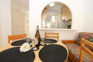 a dining room table with a bottle of wine and glasses at COSTA DAURADA APARTAMENTS - Colibri Beach in Cambrils