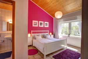a bedroom with a white bed and a pink wall at Apartment am Wirschbach in Weiersbach
