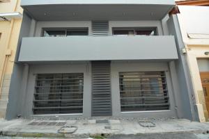 a building with two windows and a white awning at Suites 51 in Piraeus