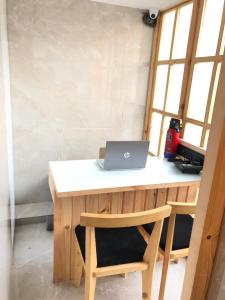 a laptop computer sitting on a wooden desk with a chair at Hotel Rooms Dadar near Station in Mumbai