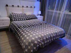 łóżko z czarno-białą kołdrą w sypialni w obiekcie Moderno apartamento Torremolinos centro w mieście Torremolinos