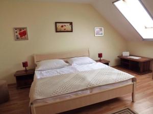 a bedroom with a bed with two tables and a window at Vad-Virág Vendégház in Fertőrákos