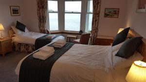 a hotel room with two beds and a window at Ronebhal Guest House in Oban