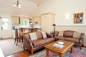 a living room with two couches and a table at Braestone Lodge in Dunedin