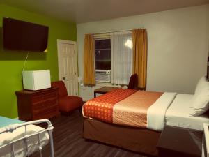 um quarto de hotel com uma cama e uma televisão em Stuart Hotel em Los Angeles