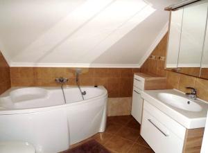 a bathroom with a white tub and a sink at Vad-Virág Vendégház in Fertőrákos +6 photos