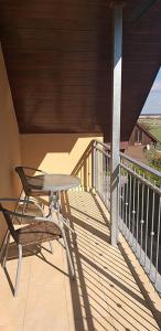 a table and a chair sitting on a porch at Vad-Virág Vendégház in Fertőrákos