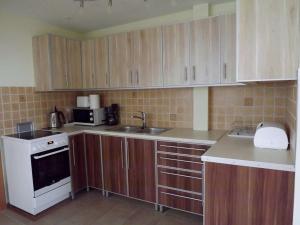 a kitchen with wooden cabinets and a white stove top oven at Vad-Virág Vendégház in Fertőrákos