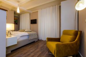 1 dormitorio con 1 cama y 1 silla amarilla en Villa Flores Studio Apartment en Dubrovnik