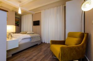 a bedroom with a bed and a yellow chair at Villa Flores Studio Apartment in Dubrovnik